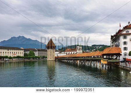 Lucerne Switzerland - June 14 2017: Historic city center of Lucerne with Famous Chapel bridge Lake Lucerne and Pilatus mountain on background at sunrise