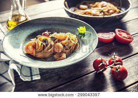 Pasta Spaghetti On Plate And Pan With Shrimp Tomato Sauce Toatoes And Herbs. Italian Or Mediterranea