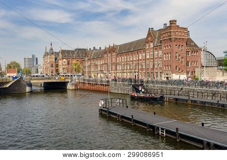 Amsterdam, Netherlands - 22 April 2019: Tourists sightseeng at Canal Boat City Hopper near the Central Station of Amsterdam.
