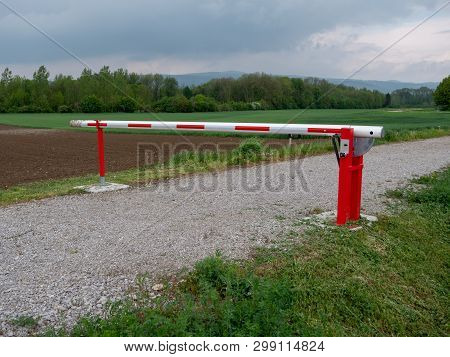 Closed Red And White Boom Gate Or Boom Barrier On A Gravel Path In The Countryside