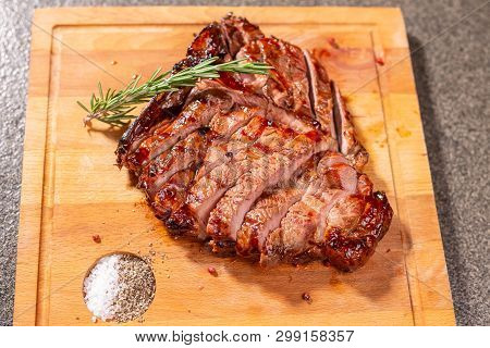 Food And Horse Meat Concept - Roast Meat On Cutting Board With Cumin