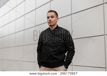 Cute Young Attractive Man In Beige Stylish Pants With A Hairstyle In A Fashionable Light Jacket Posi