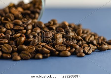 Scattered Coffee Beans On A Blue Background. Horizontal Photography