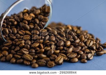 Scattered Coffee Beans On A Blue Background. Horizontal Photography