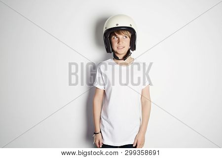 Portrait Of Young Cute Cheerful Teen Boy In White Tshirt Draming To Ride A Motorcycle Isolated On Wh