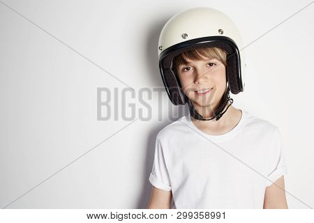 Smiling Young Cute Cheerful Teen Boy In White Tshirt Draming To Ride A Motorcycle Isolated On White 