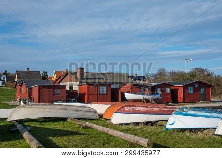 Old Fishing Boats In Front Of Red Sheds In Port Of Kalvehave In Denmark