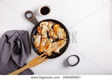 Fried Eryngii Mushrooms In Cast-iron Pan On White Table. Grilled Slices Of King Oyster Mushrooms. To