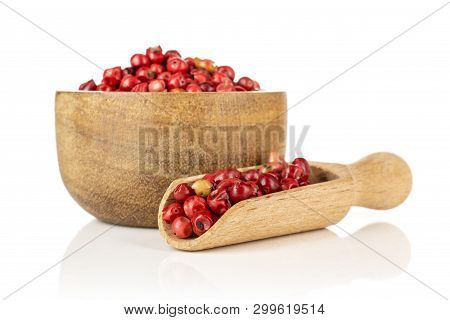 Lot Of Whole Peruvian Pink Pepper In A Wooden Bowl With Wooden Scoop Isolated On White Background
