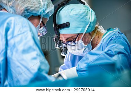 Surgeon And His Assistant Performing Cosmetic Surgery On Nose In Hospital Operating Room. Nose Resha