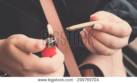 Marijuana Joint In The Female Hand Close-up. Woman Smoking Medical Marijuana Joint Uotdoors.