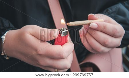 Marijuana Joint In The Female Hand Close-up. Woman Smoking Medical Marijuana Joint Uotdoors.