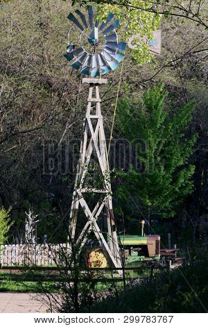 Windmill On A Wood Tower Pumping Water To The Livestock