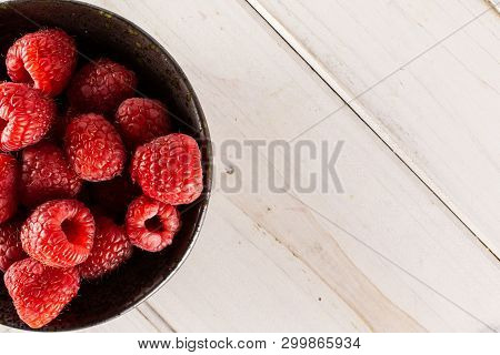 Lot Of Whole Fresh Red Raspberry On Grey Ceramic Plate Flatlay On White Wood