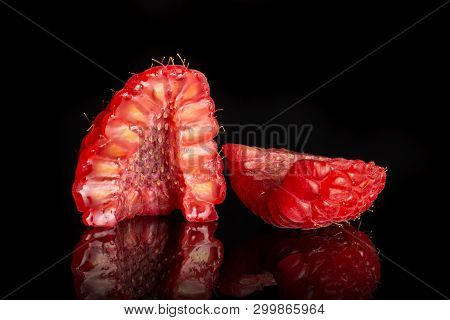 Group Of Two Halves Of Fresh Red Raspberry One Cut In A Cross Section Isolated On Black Glass