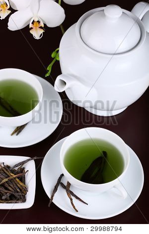 Tasse grüner Tee mit weißer Orchidee Teezeit