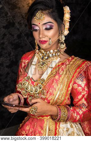 Portrait Of Very Beautiful Young Indian Bride In Luxurious Bridal Costume With Makeup And Heavy Jewe
