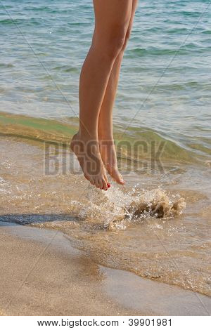 belle gambe di una bella ragazza camminare in acqua
