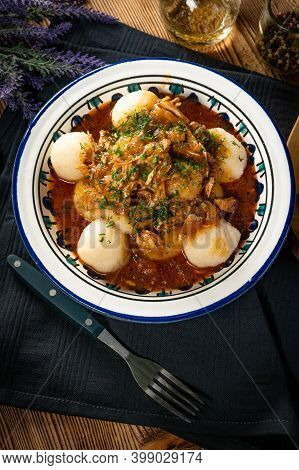 Dumplings With Turkey And Chorizo Sauce In A Painted Bowl.