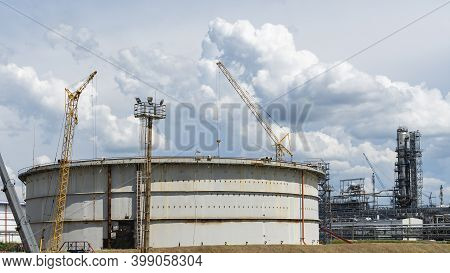 Refinery Factory Oil Storage Tank And Pipeline Steel At Day On Framatic Sky Background. Oil Refinery