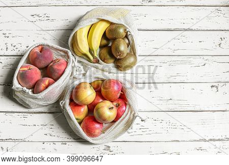 Organic Fruits In Reusable Eco Friendly Natural Bag On The White Wooden Background
