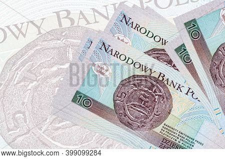 10 Polish Zloty Bills Lies In Stack On Background Of Big Semi-transparent Banknote. Abstract Present