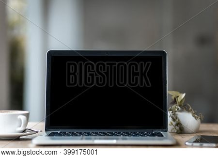 Mockup Of Laptop Computer With Empty Screen With Coffee Cup And Smartphone On Table Of The Coffee Sh