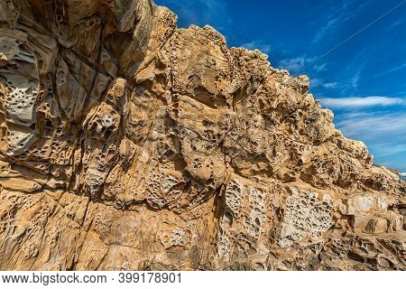 Sandstone Cliff With Honeycomb Weathering N Blue Sky Background