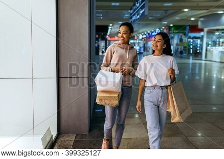 Girls with bags at the showcase in clothing store