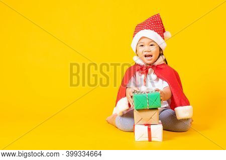 Asian Little Cute Child Girl Smile Face, A Kid Dressed In Red Santa Claus Hat The Concept Of Holiday