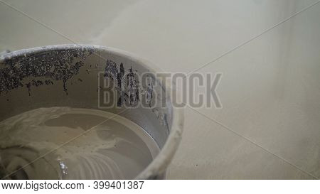 Mixing The Building Mixture In A Bucket With A Mixer. Bricklayer Mixing Cement In Bucket. Concrete M