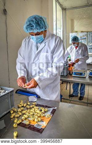 Guaranda, Bolivar / Ecuador - November, 2013: A Worker At A Local Chocolate Factory, In A White Coat