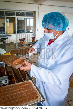 Guaranda, Bolivar / Ecuador - November, 2013: A Worker At A Local Chocolate Factory, In A White Coat