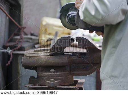 Work With Metal Grinder And Old Vise. The Vise Is Closed Up In A Metal Workshop. Heavy Industry, Met