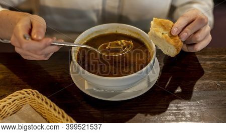 Georgian Cuisine. Lifestyle Photo Of Female Hands Holding Bread And Spoon Of Harcho Soup.