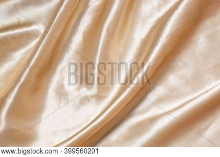 The Texture Of The Fabric Silk. Beige Fabric Pleated. Close-up. Can Be Used As A Background.