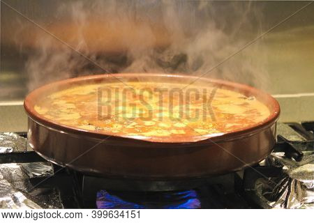 Boiling Broth With Rabbit Meat And Sausages In A Clay Pot To Do A Spanish Dish Called Costra