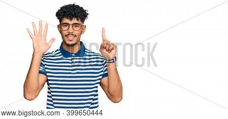 Young arab man wearing casual clothes and glasses showing and pointing up with fingers number six while smiling confident and happy. 