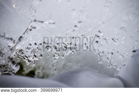 Winter Water Spring In Of Icicles And Ice Glistens And Shimmers In The Morning Sun. Splashes Of Wate