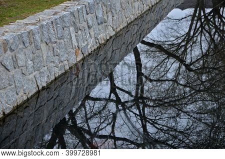 The Stone-clad Retaining Walls Of The River Pond Reservoir Or Dock Are Inaccessible To Humans. The A