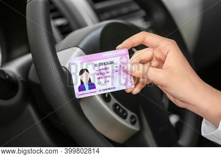 Woman With Driving License In Car Salon