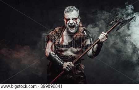 Savage And Powerful Antique Barbarian In Light Armour With Fur And Holding Two Handed Axe In Dark Fo
