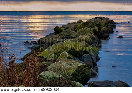 A Beautiful Sunset Over The Green Boulders On A Wave Breaker. Photo From Hallevik, Blekinge County, 