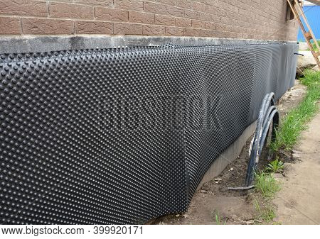 Protecting The Basement Foundation Outside Of A Brick House From Water And Moisture Using A Foundati
