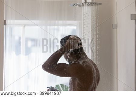 Happy Millennial African Ethnicity Man Enjoying Morning Body Cleansing Routine.