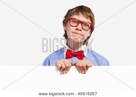 Image of confused boy holding white square. Place for advertisement