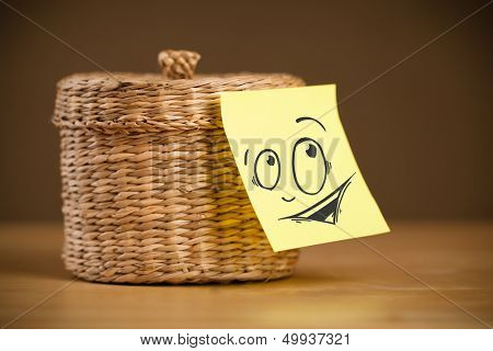 Drawn smiley face on a post-it note sticked on a jewelry box