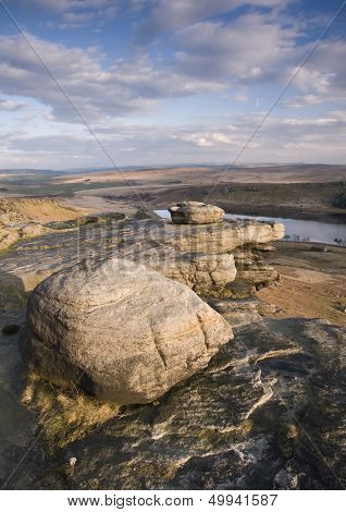 Millstone grit wind shaped boulders on a ridge above a Yorkshire reservoir