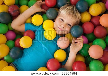 Happy boy playing in ball pool at a party