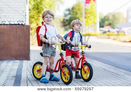 Two Little Siblings Children Having Fun On Bikes In City, Outdoors.